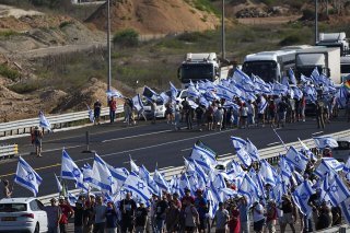 Des milliers de manifestants, selon les médias, se sont rassemblés à l'aéroport Ben Gourion de Tel-Aviv, agitant des drapeaux israéliens blanc et bleu, klaxonnant et criant des slogans hostiles à la réforme.